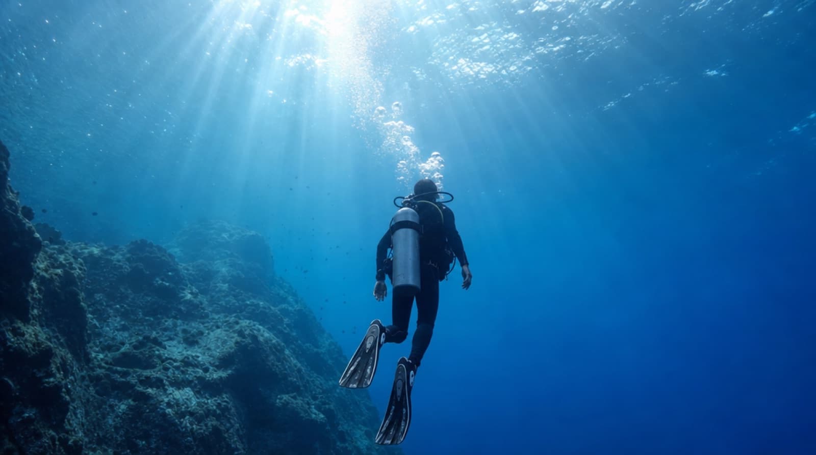 Scuba diver ascending slowly toward the surface to avoid decompression sickness